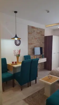 a living room with a table and blue chairs at Andre P05 Milmari in Kopaonik
