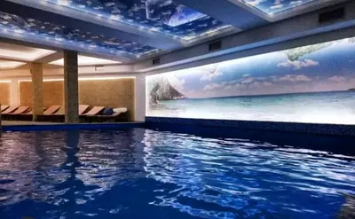 a swimming pool in a hotel with a painting on the wall at Andre P05 Milmari in Kopaonik