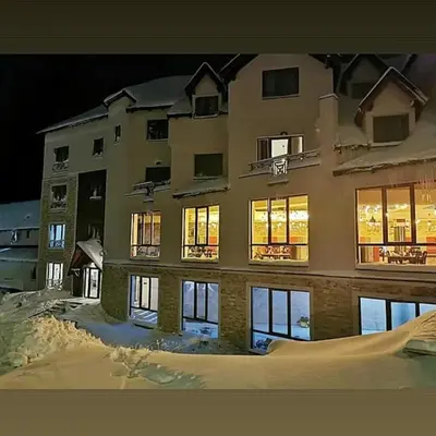 a large building in the snow at night at Andre P05 Milmari in Kopaonik