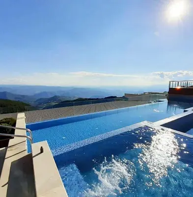 a swimming pool with a view of the mountains at Dream Lux Apartman Kopaonik in Kopaonik