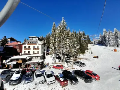 a group of cars parked in the snow in front of a building at Apartman sa kaminom Vila Mina in Kopaonik