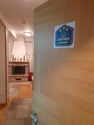 a sign on the door of a building at Apartman sa kaminom Vila Mina in Kopaonik