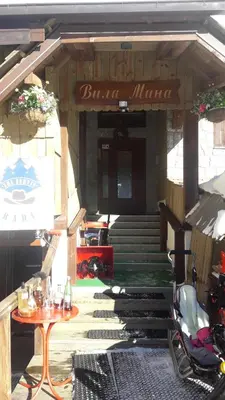 a entrance to a building with a table and stairs at Apartman sa kaminom Vila Mina in Kopaonik