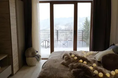 a bedroom with a bed and a large glass door at Ski & Spa Apartment S20 Milmari Resort Kopaonik in Kopaonik