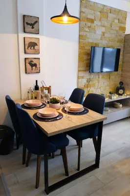 a dining room table with chairs and a television at Ski & Spa Apartment S20 Milmari Resort Kopaonik in Kopaonik