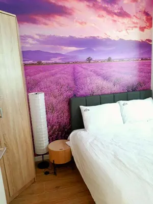 a bedroom with a bed in front of a lavender field at Silver Kop 2 Apartmani in Kopaonik