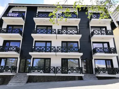 an apartment building with black and white windows at Silver Kop 2 Apartmani in Kopaonik