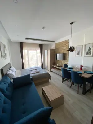a living room with a blue couch and a table at Mount Apartments Milmari in Kopaonik
