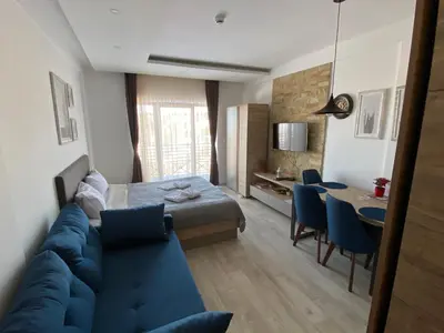 a living room with a blue couch and a table at Mount Apartments Milmari in Kopaonik