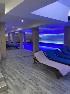 a swimming pool in a room with blue lighting at Mount Apartments Milmari in Kopaonik