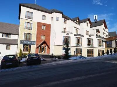 a large white building on the side of a street at Milmari-Apartman MARA L30 in Kopaonik