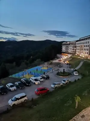 a parking lot with cars parked in a lot at Milmari-Apartman MARA L30 in Kopaonik