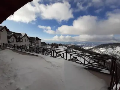 a bridge covered in snow next to some houses at TeonaLux Milmari Resort P84 in Kopaonik