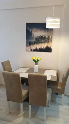 a dining room table with chairs and a vase of flowers at Milmari resort Sara P61 in Kopaonik