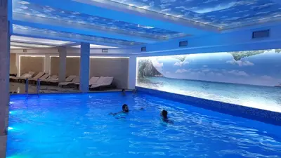 a hotel swimming pool with two people in the water at Milmari resort Sara P61 in Kopaonik