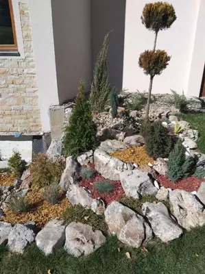 a garden with rocks and trees in a yard at Milmari resort Sara P61 in Kopaonik
