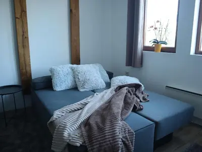 a blue couch with a blanket on it in a room at JOPA Suncani breg in Kopaonik