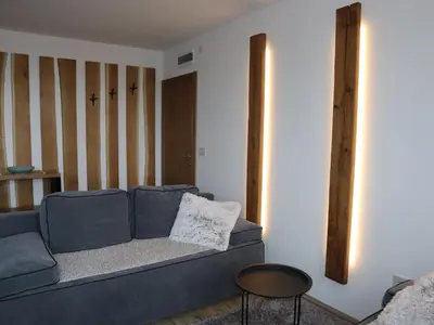 a living room with a blue couch and a mirror at JOPA Suncani breg in Kopaonik