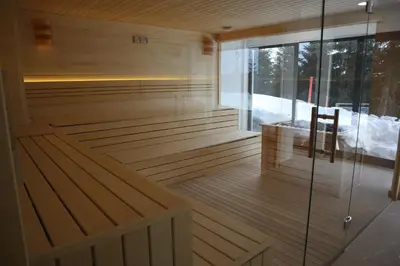 a sauna with a bench and a chair in it at JOPA Suncani breg in Kopaonik