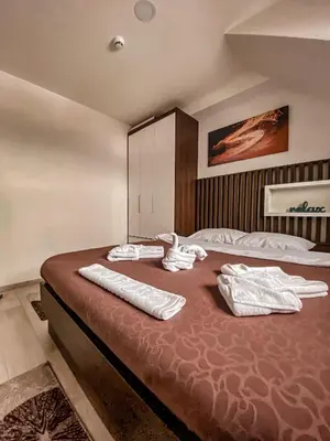a bedroom with a large bed with towels on it at Apartmani Džanković in Kopaonik