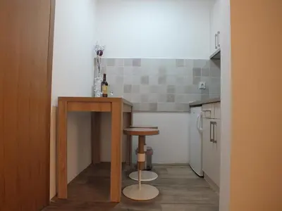 a small kitchen with a table and a stool at SUNCANI BREG - STUDIO 11 in Kopaonik
