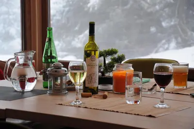 a table with wine bottles and glasses on it at SUNCANI BREG - STUDIO 11 in Kopaonik