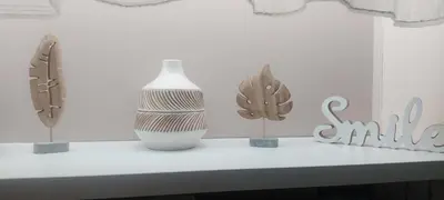 a table with a white vase and some plants on it at Square Apartment in Paraćin