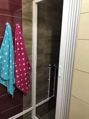 a couple of towels hanging on a wall in a shower at Square Apartment in Paraćin