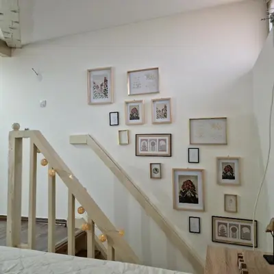 a staircase with framed pictures on the wall at Square Apartment in Paraćin