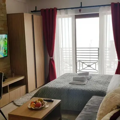 a bedroom with a bed and a table with a bowl of fruit at Milmari Resort Maša S6 in Kopaonik