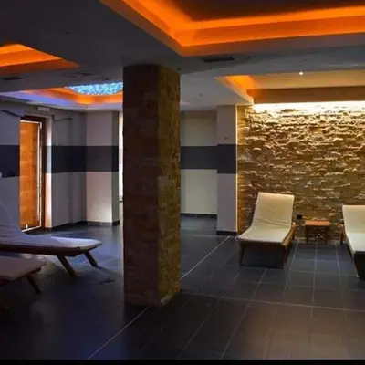 a waiting room with chairs and a stone wall at Milmari Resort Maša S6 in Kopaonik