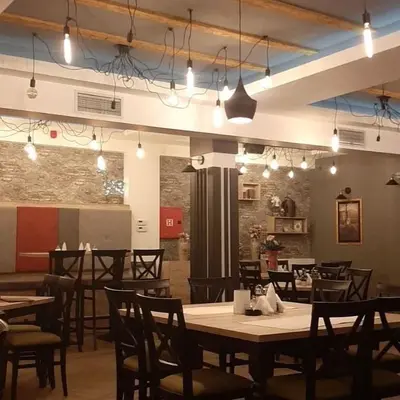 a dining room with tables and chairs and lights at Milmari Resort Maša S6 in Kopaonik