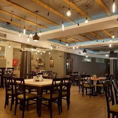 a dining room with tables and chairs and lights at Milmari Resort Maša S6 in Kopaonik