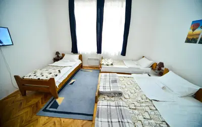 a room with three beds and a window at Apartman Lux in Pirot