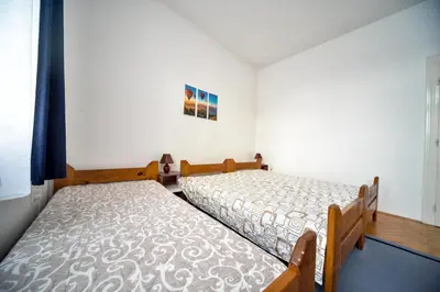 two twin beds in a room with a window at Apartman Lux in Pirot