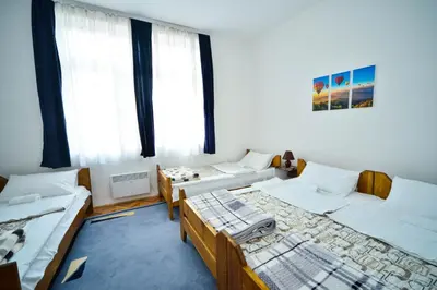 a room with three beds and two windows at Apartman Lux in Pirot