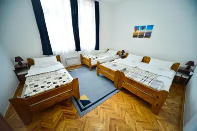 a room with two beds and a large window at Apartman Lux in Pirot
