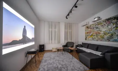 a living room with a couch and a painting on the wall at Apartman Lux in Pirot
