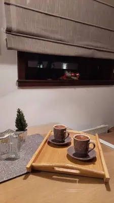 two cups of coffee on a wooden tray on a table at Vila Pahulja A3 in Kopaonik
