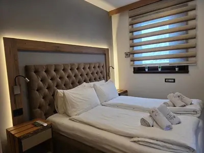 a bedroom with a large bed with two towels on it at Vila Pahulja A3 in Kopaonik