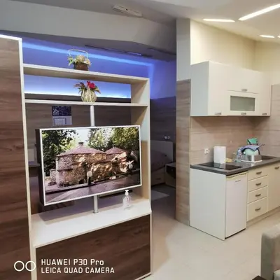 a living room with a tv on a shelf at Apartman UZOR in Soko Banja