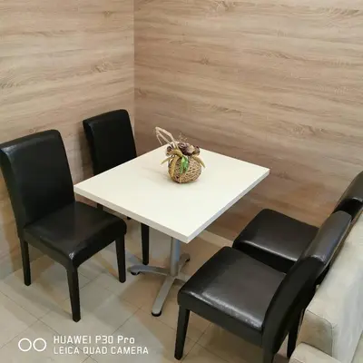 a white table with four black chairs and a basket on it at Apartman UZOR in Soko Banja