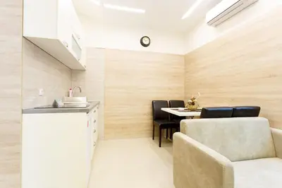 a room with a table and chairs and a kitchen at Apartman UZOR in Soko Banja