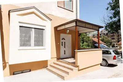 a house with a staircase leading to a door at Apartman UZOR in Soko Banja