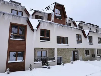 an apartment building with snow on the ground at Sky Cabin Apartments - FREE GARAGE in Kopaonik