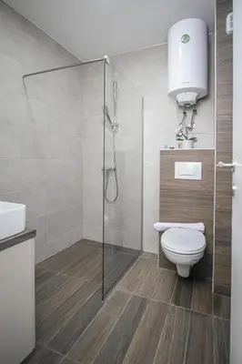 a bathroom with a toilet and a glass shower at Sky Cabin Apartments - FREE GARAGE in Kopaonik