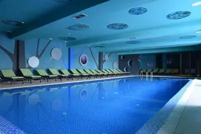 a swimming pool in a hotel with chairs around it at Private apartman 5b23 in Kraljevi cardaci in Kopaonik