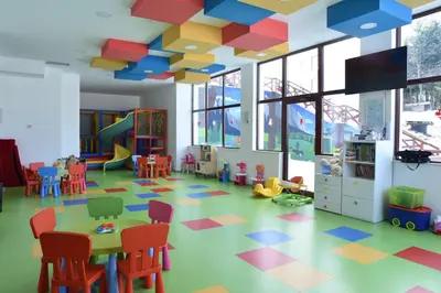 a play room with a table and chairs at Private apartman 5b23 in Kraljevi cardaci in Kopaonik