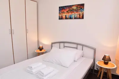 a bedroom with a white bed with towels on it at Private apartman 5b23 in Kraljevi cardaci in Kopaonik