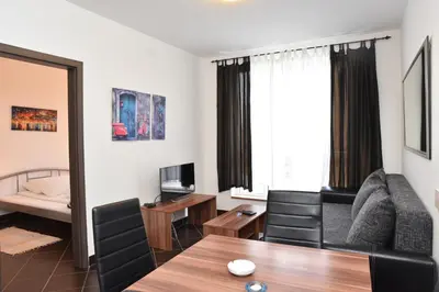 a living room with a couch and a table with chairs at Private apartman 5b23 in Kraljevi cardaci in Kopaonik